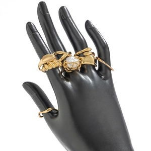 Detail of a gold-plated ring set featuring an irregular pearl and geometric designs