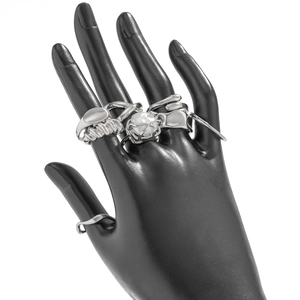 Silver liquid metal rings set with twisted texture and pearl detail on display stand