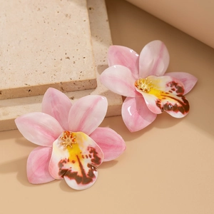 Detailed close-up of handmade pink orchid earrings with delicate silk-like texture