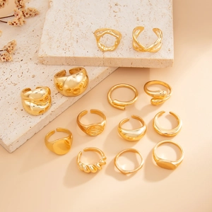 Detailed close-up of 12-piece gold geometric ring set displayed on elegant stone plates