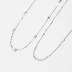 Detail of silver double-layered body chain featuring minimalist bead and snake bone link design