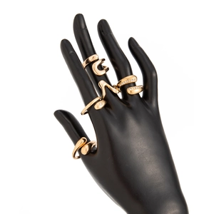 Detail view of a four-piece gold-plated ring set featuring a snake motif and pave crystals