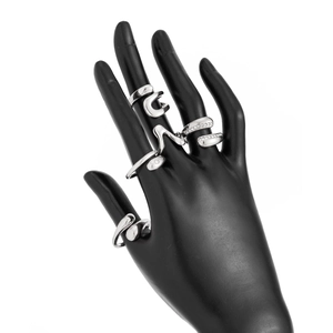Close-up of polished silver liquid metal rings and zircon pavé bands on a model hand