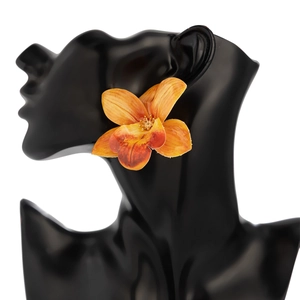 Detailed view of large orange flower earrings with gradient petals and gold center