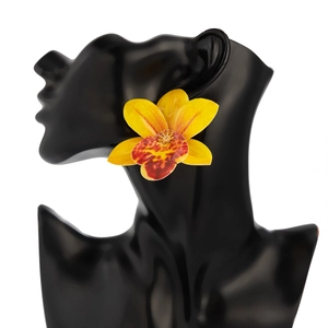 Detail of a large yellow orchid earring with realistic spots on a black display stand