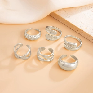Detailed close-up of various silver geometric adjustable open rings with polished finish