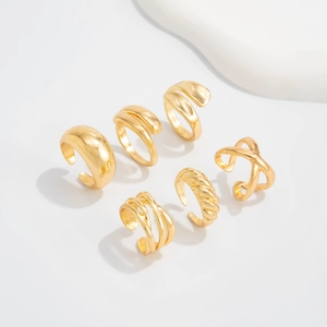 Detail view of six minimalist adjustable gold-plated geometric rings on white background