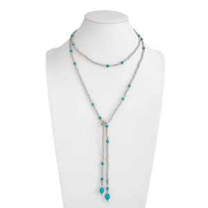 Detail van zilveren kralenketting met turquoise stenen en elegante metalen kwastjes