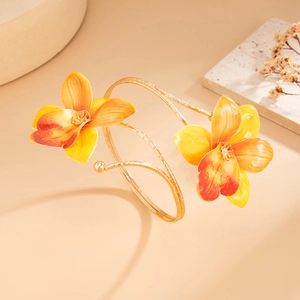 Detailed view of a golden spiral bracelet featuring vibrant yellow 3D orchid flowers