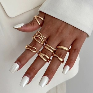 Close-up of a stacked gold ring set featuring irregular geometric and wavy waterdrop designs