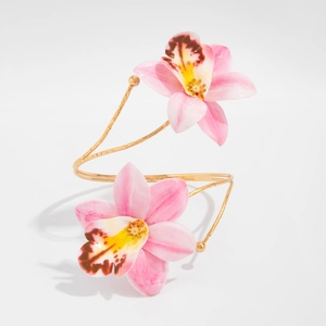Detail of pink orchid flowers on a gold spiral arm cuff with fine floral textures