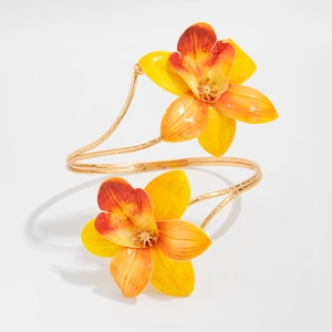 Detailed macro view of gold spiral bangle featuring vibrant yellow and orange fabric flowers