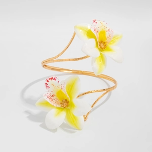 Detailed macro view of realistic white orchid blossoms on a golden spiral arm cuff bracelet