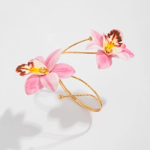 Detailed macro view of an open gold bangle featuring realistic pink enamel orchids