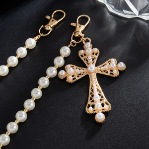 Detail of gold hollow cross pendant with pearls and matching pearl bead waist chain