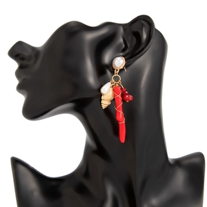 Detalle de pendientes náuticos con coral rojo, perla blanca y colgantes de caracola