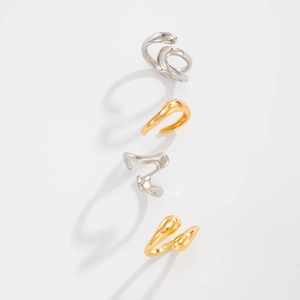 Artistic teardrop hug rings in gold and silver showing liquid metal flow design