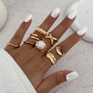 7-piece gold-tone ring set featuring snake, pearl, croissant, and lava texture designs