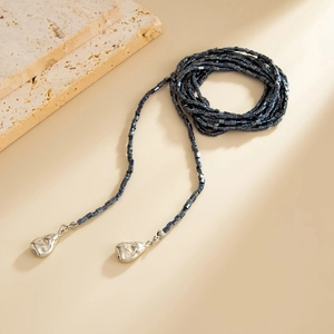 Detailopname van hiphop-parelketting met zilveren lava-hangers en donkergrijze kralen