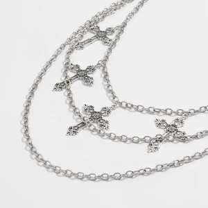 Detail of silver gothic cross pendants on multilayered punk style metal waist chain