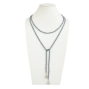 Detailweergave van lange Y-vormige kralenketting met zilveren druppelhangers op een buste