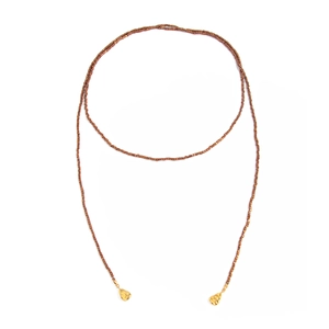 Macro detail van lange bruine kralenketting met gouden organische metalen druppelhangers