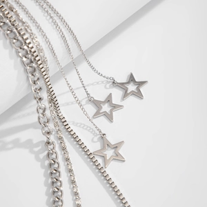 Close-up of multi-layer silver chains featuring punk cross and star pendants style