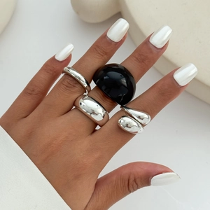 Set van zilveren vloeibare metalen ringen en zwarte hars ring gedragen op handen