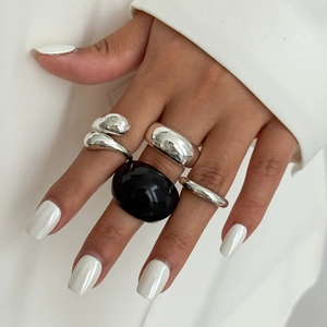 Detailopname van een minimalistische zilveren ringenset met zwarte hars edelsteen