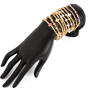 Détail de bracelets à perles dorées multicouches avec croix colorées sur main