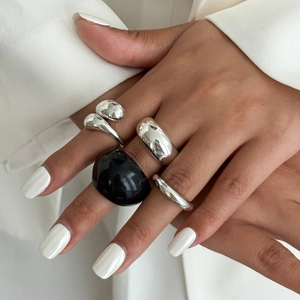 Minimalistische zilveren en zwarte hars ringen set met een witte blazer