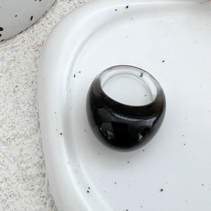 Nahaufnahme eines schwarzen Harz-Kuppelrings auf einem gesprenkelten Keramiktablett