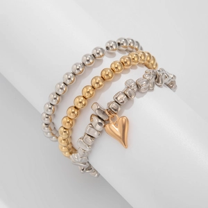 Vista dettagliata del set di tre bracciali elastici con ciondolo a cuore dorato su perle