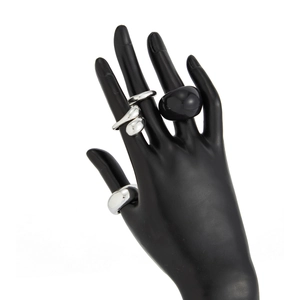 Detail van zilveren druppelringen en zwarte steen ring voor moderne styling