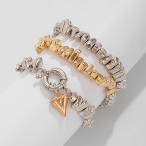 Macro di tre braccialetti con perline irregolari e un ciondolo a forma di cuore d'oro