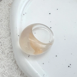 Detail eines klobigen Bernstein-Resinrings mit breitem Band auf Steintablett