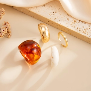 Detail van hars en gouden ringenset op zijden achtergrond met zachte schaduwen