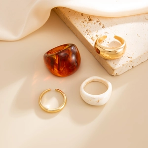 Macro detail of retro resin rings with marble patterns and gold textured metal bands