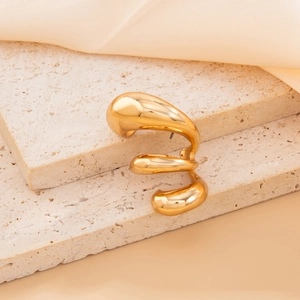 Detailed macro view of gold-plated geometric drop earrings on luxury stone and silk background