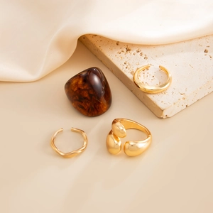 Detailopname van vergulde ringen en marmeren steen op luxe zijden achtergrond