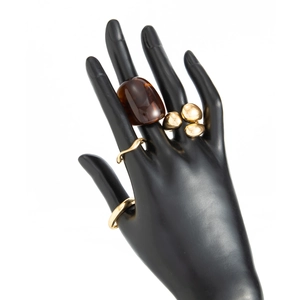 Close-up of golden ring set featuring amber oval stone and polished wave bands