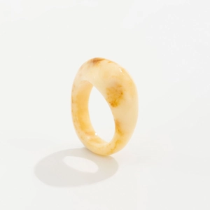 Detailansicht eines breiten Kunstharzrings mit creme-brauner Marmorierung auf Weiß