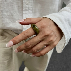 Nahaufnahme eines olivgrünen Harzrings mit Marmortexur am Zeigefinger für Damen