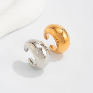 Gros plan de boucles d'oreilles C en métal poli doré et argenté à l'effet miroir