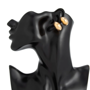 Gros plan de boucles d'oreilles clips dorées polies sur un mannequin noir artistique
