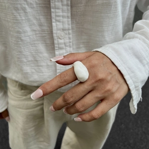 Künstlerischer weißer klobiger Ring aus Kunstharz an der Hand für einen minimalistischen Look