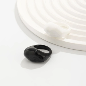 Makroansicht minimalistischer unregelmäßiger Harzringe in Schwarz und Weiß, glänzend