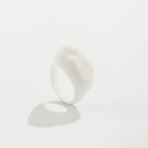 Makroaufnahme eines minimalistischen weißen Harzrings mit organischer Form und Glanz