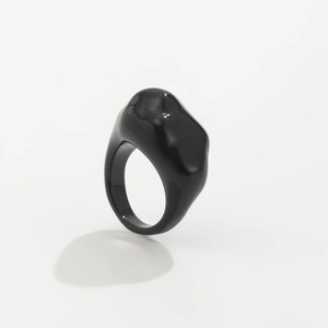 Makroaufnahme eines glänzenden schwarzen Harzrings mit modernem Wellendesign