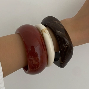 Set of three retro irregular resin bangles in deep red, marble white, and amber brown